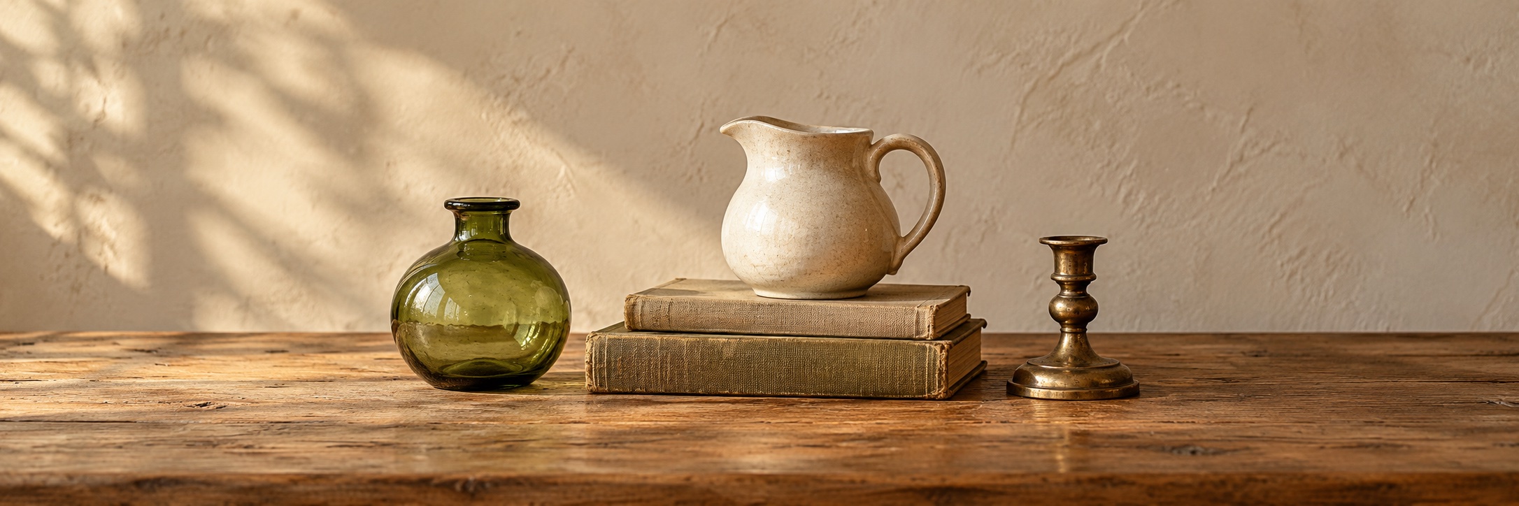 Illustrative still life of vintage-style glass, pottery, books and brass; not actual store inventory